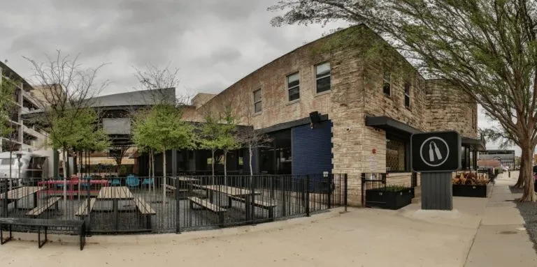 Panoramic empty brick restaurant with outdoor patio tables.