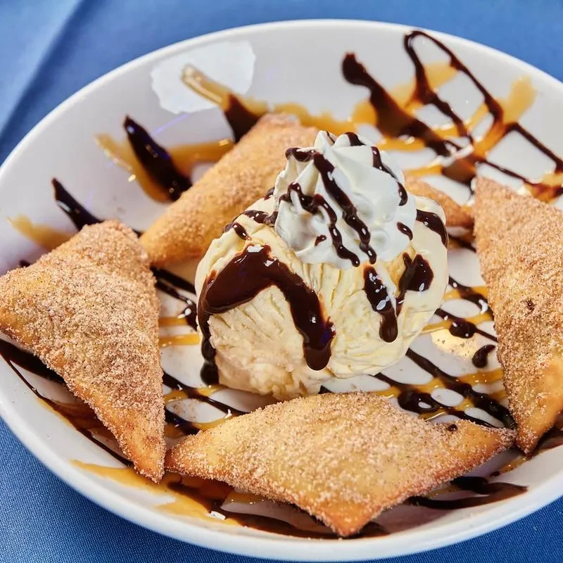 Vanilla ice cream, chocolate, whipped cream, and cinnamon-sugar fried pastries.