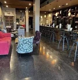 Modern bar interior with colorful lounge seating and a long dark bar.
