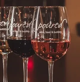 Three wine glasses with red and rosé wine, etched "poured".