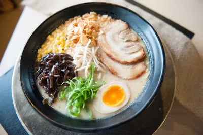 Overhead close-up of a meticulously arranged ramen bowl with toppings.