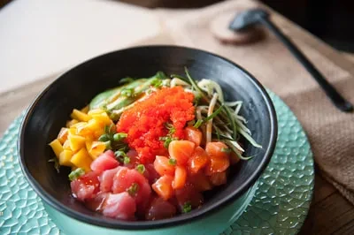 Poke bowl with tuna, salmon, mango, cucumber, and fish roe.