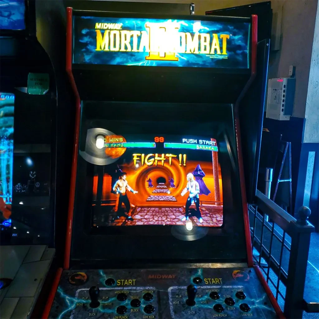 Retro Mortal Kombat II arcade machine, game in action, dimly lit room.