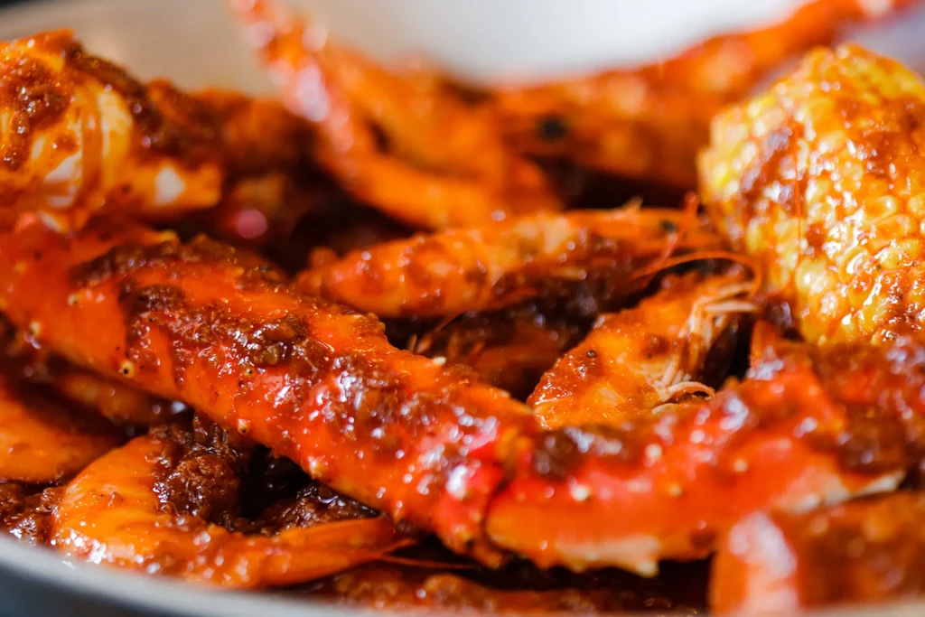 Close-up of a seafood boil featuring crab legs, shrimp, and corn.