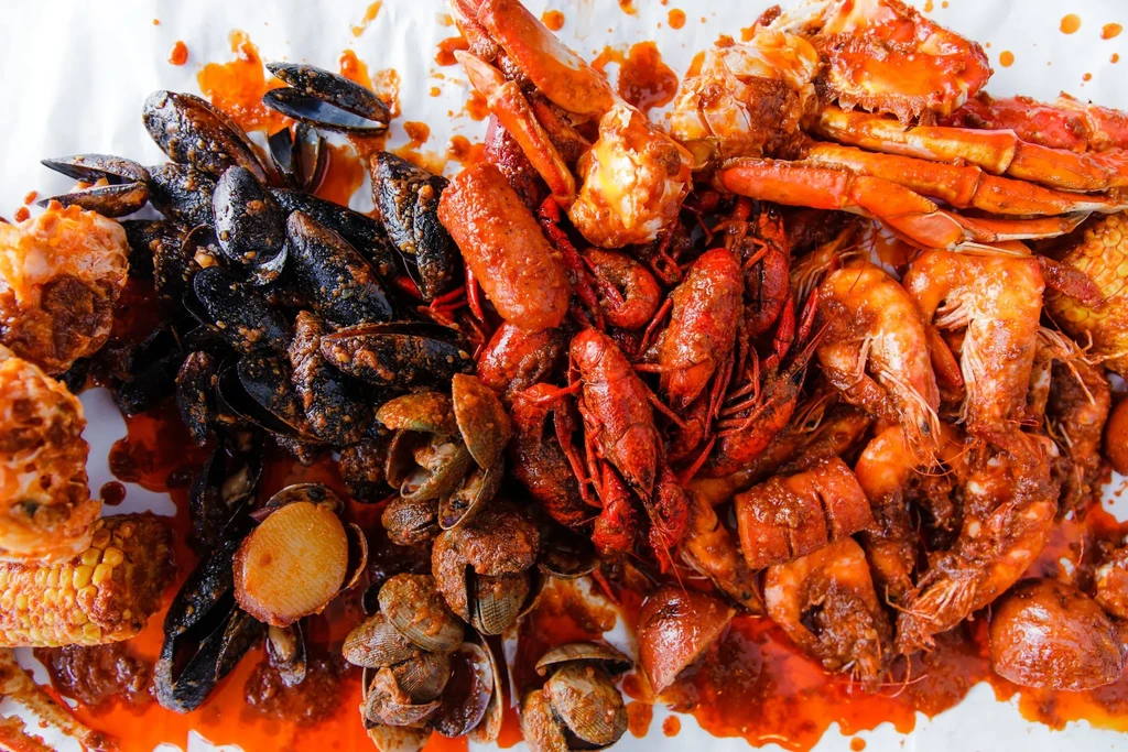 Spicy seafood boil with crab, shrimp, crawfish, mussels on butcher paper.