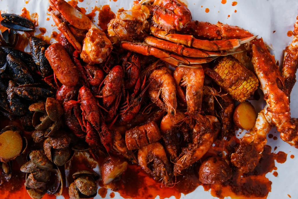 Seafood boil with mussels, crawfish, shrimp, crab legs, corn, and potatoes.