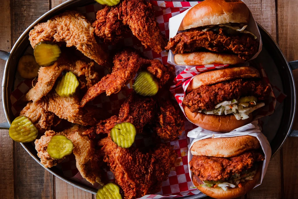 Crispy fried chicken wings and three sandwiches with pickles and coleslaw.