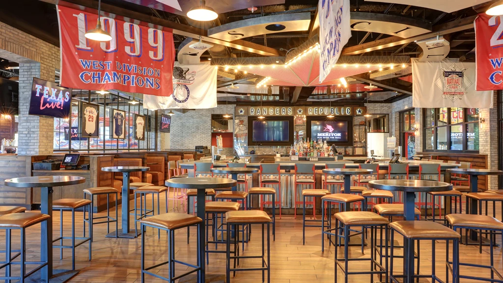 Empty modern sports bar interior with 'RANGERS REPUBLIC' sign and memorabilia.