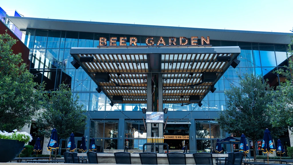 Modern glass Blue Moon Beer Garden with pergola over bar and seating.