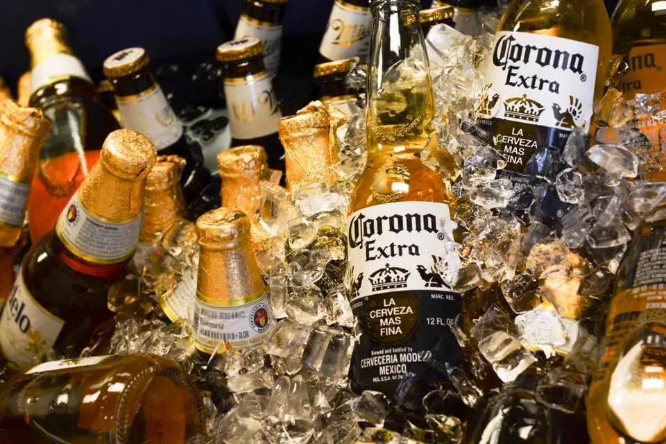 Various cold beer bottles, including Corona, nestled in sparkling ice.