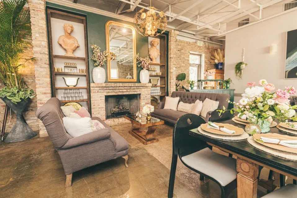 Furnished interior featuring a dining table, lounge with fireplace, and bar.