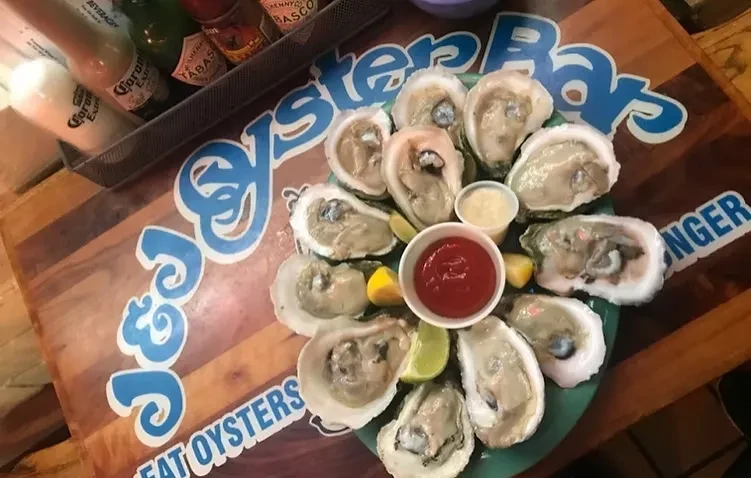 Dozen raw shucked oysters with lime, cocktail sauce, and creamy sauce.