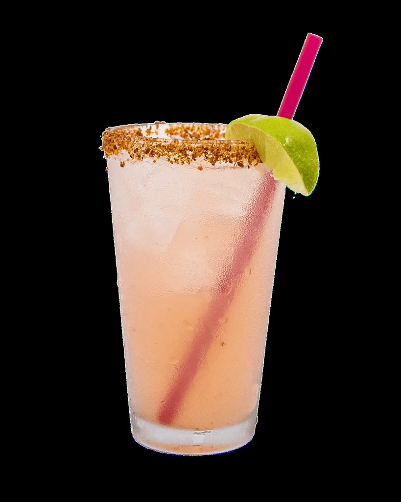 Frosted glass with peach drink, lime wedge, spiced rim, pink straw.