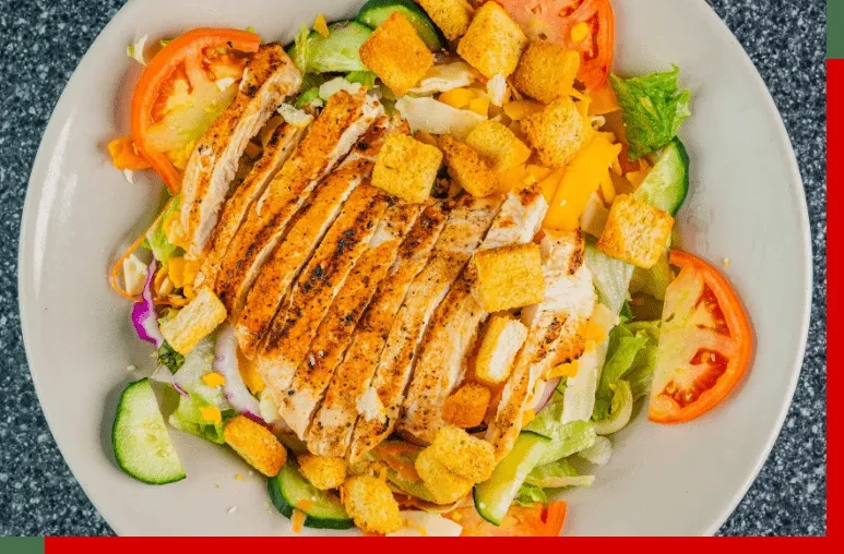Fresh chicken salad with grilled chicken, vibrant vegetables, and cheese.