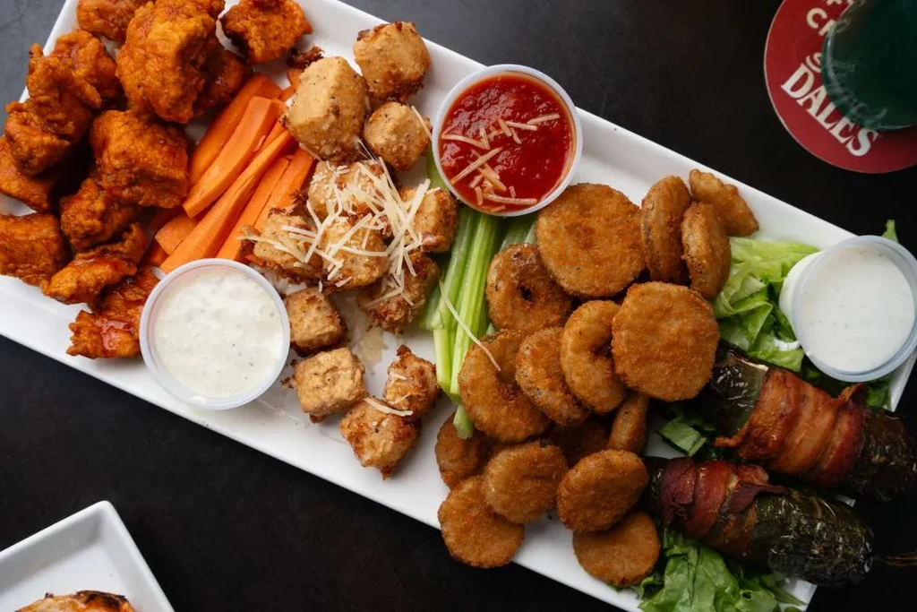 Overhead platter of fried chicken, cheese, pickles, and jalapeño poppers.