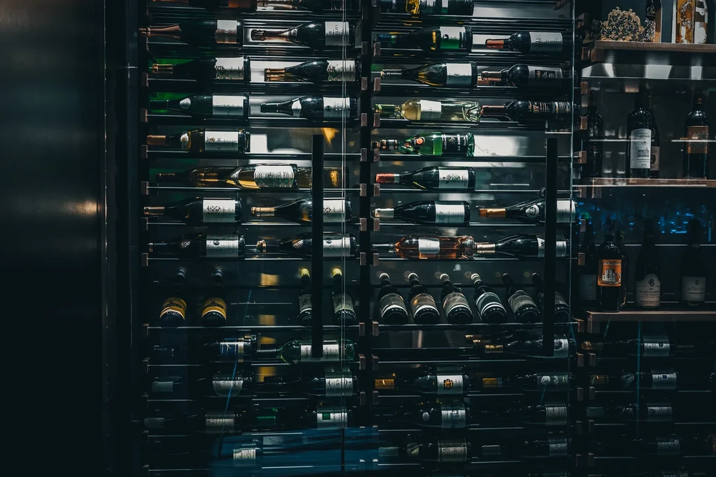 Upscale glass cabinet displaying a diverse collection of wine bottles.