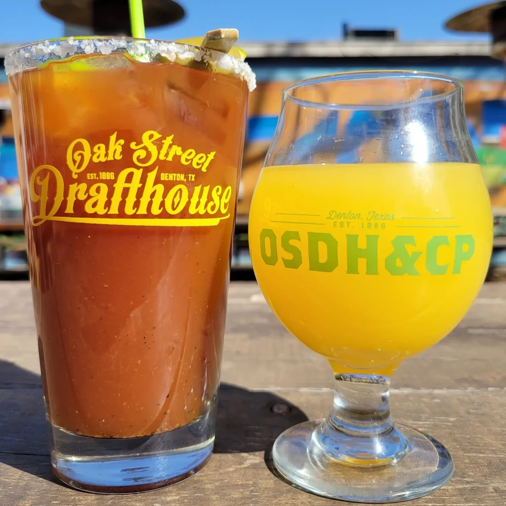 Branded Bloody Mary and yellow drink side-by-side outdoors.
