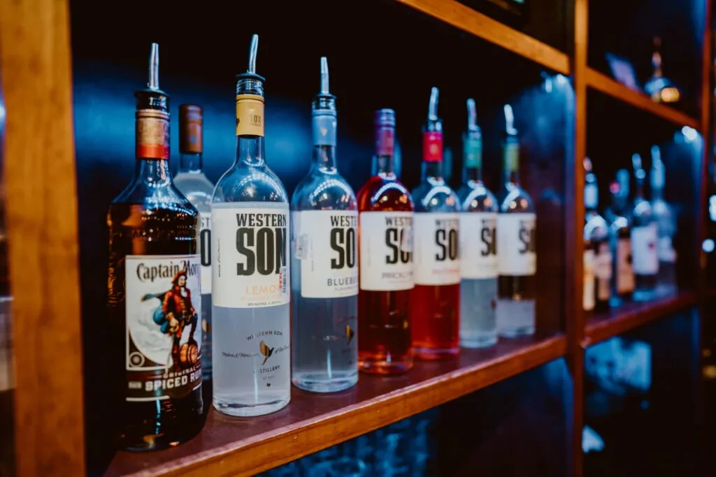 Close-up of Western Son and Captain Morgan liquor bottles with pour spouts.