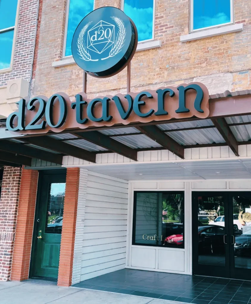 d20 tavern building exterior with brick facade, signs, and glass entrance.