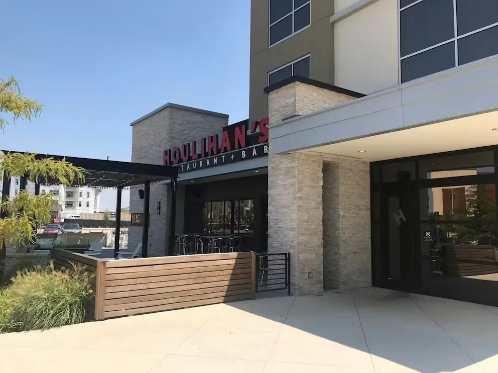 Houlihan's Restaurant and Bar exterior with stone, dark windows, patio.