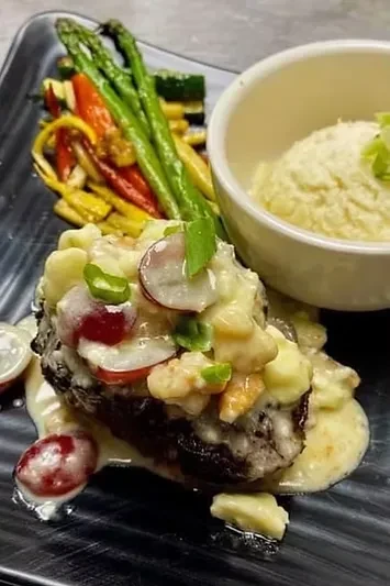 Professionally plated dark meat, creamy sauce, asparagus, and purée.