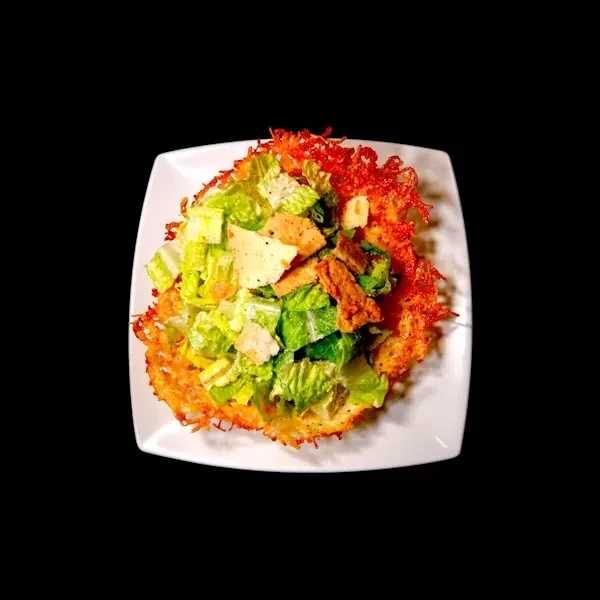 Close-up of a fresh salad in a golden-brown crispy cheese bowl.