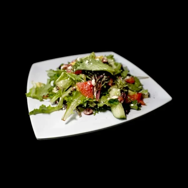 Fresh mixed green salad with cucumber, tomato, olives, and feta.