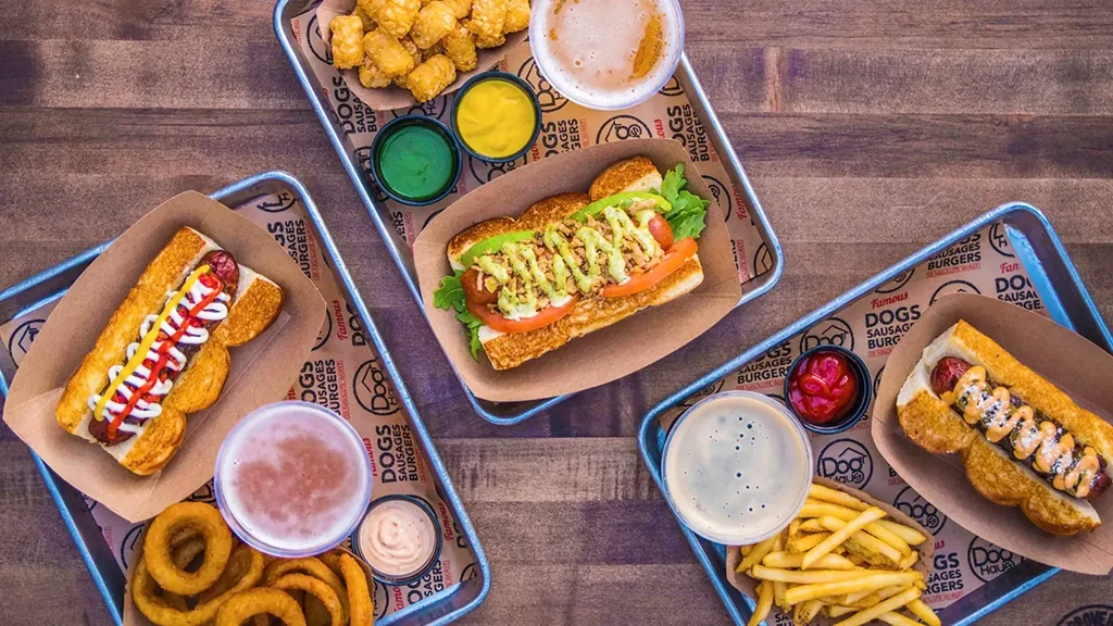 Overhead shot: Three trays of hot dogs, fries, and drinks.