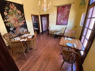 Warm, traditional dining room with wooden furniture and ornate wall tapestries.