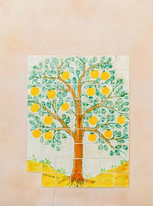 Tiled mural of a lemon tree with yellow fruit, signed J. Corce.