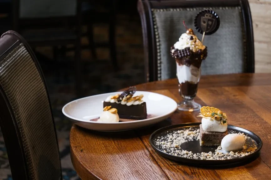Three desserts: chocolate cake, sundae, and cake with meringue and tuile.