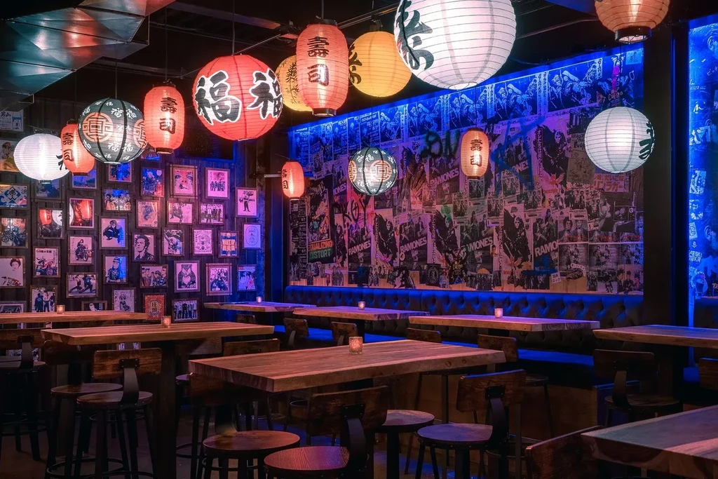 Empty, vibrant restaurant interior with Japanese lanterns and Ramones posters.