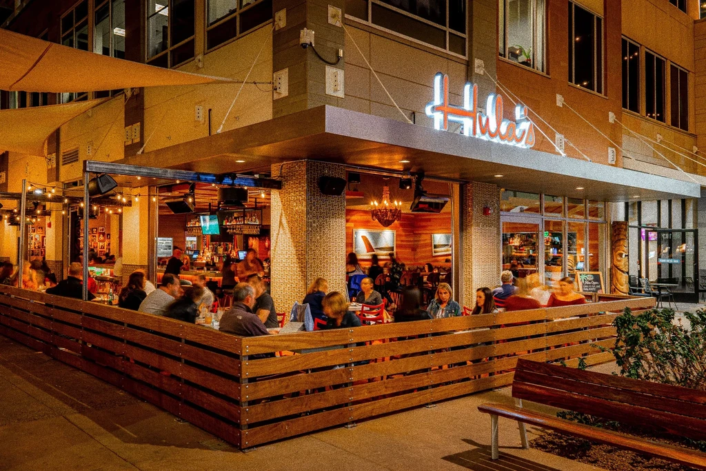 Hula's restaurant at night, its lit patio filled with diners.