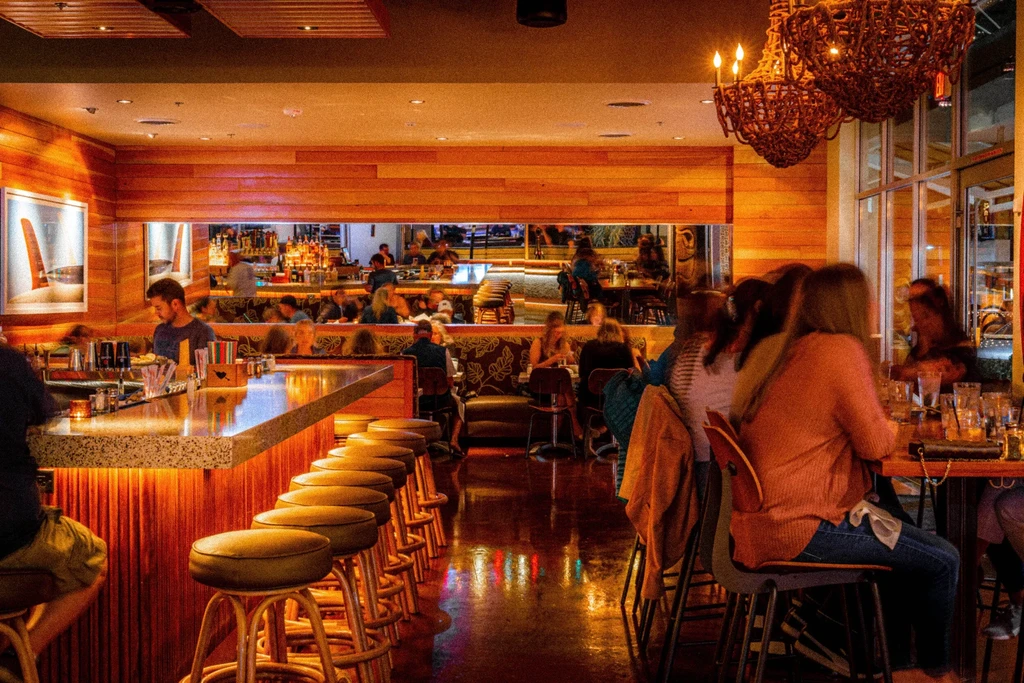 Warmly lit, wood-paneled restaurant and bar with patrons.