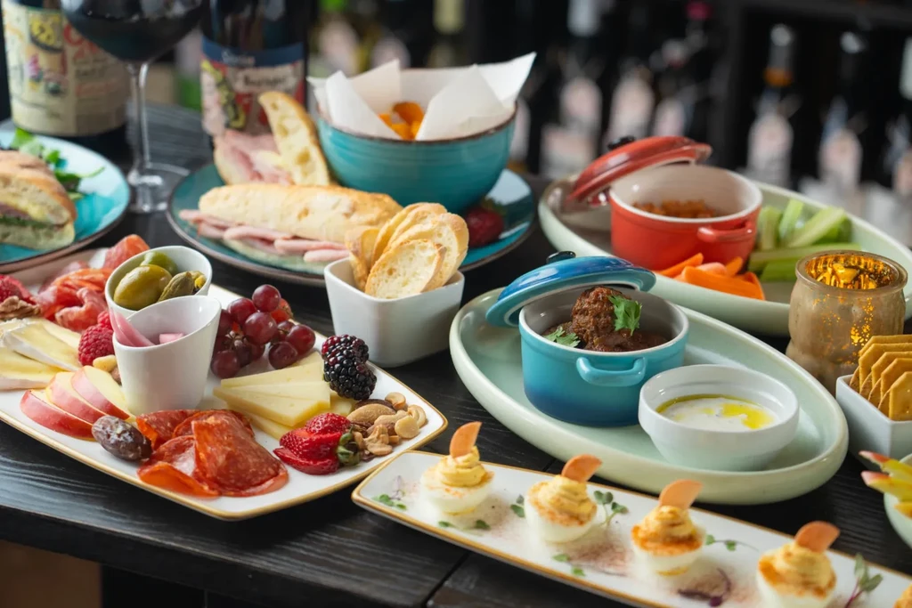 A lavish spread of charcuterie, appetizers, deviled eggs, and red wine.