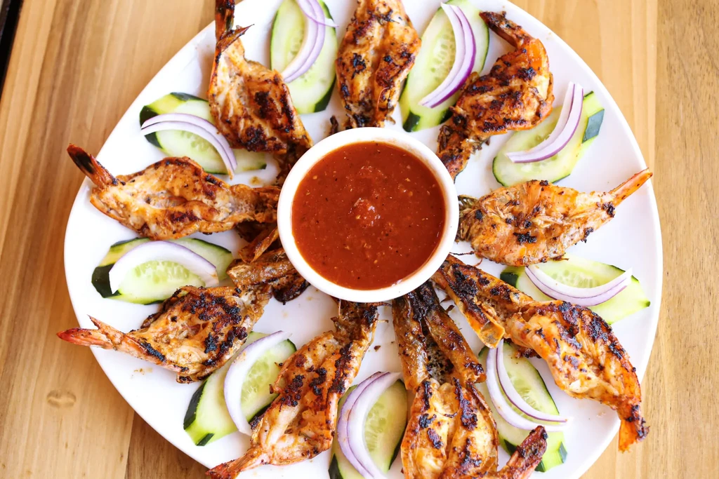 Radial grilled shrimp with cucumber, red onion, and dipping sauce.