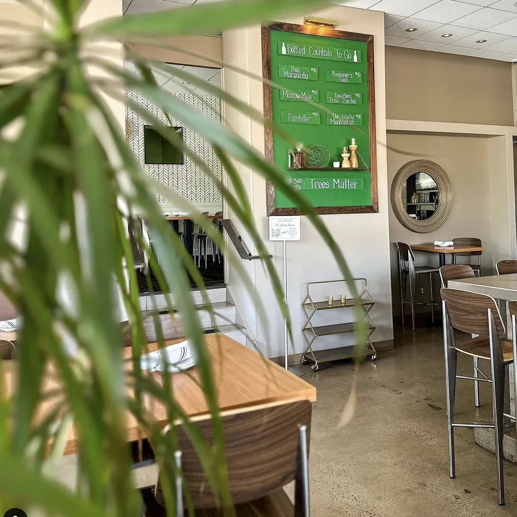 Modern casual restaurant interior with a chalkboard advertising bottled cocktails to-go.