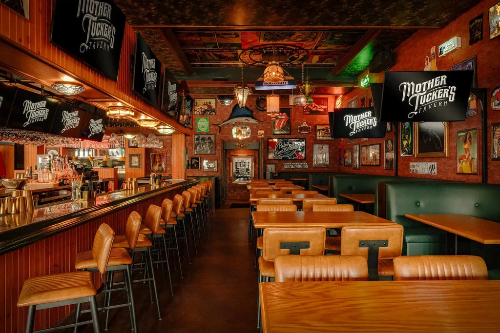 Warmly lit rustic bar and dining room, wooden furniture, eclectic decor.