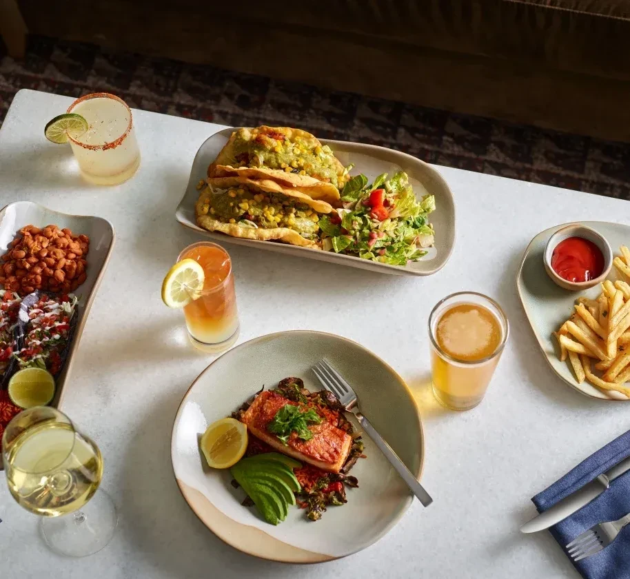 Various plates of food and drinks on a restaurant table.