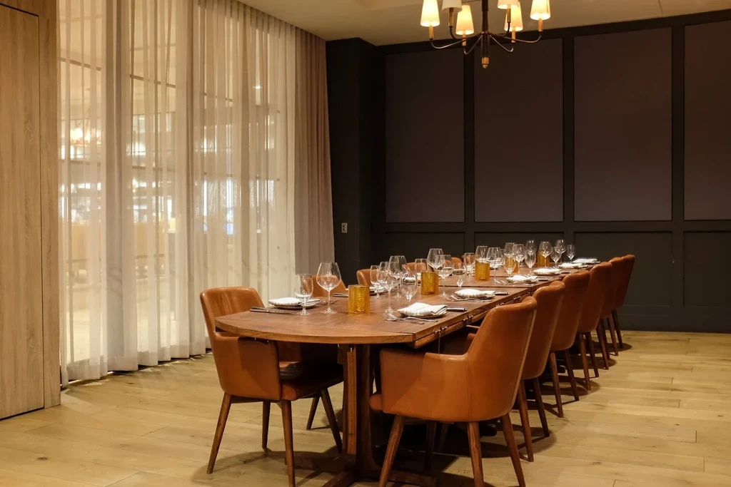 Elegant private dining room, long wooden table set for a large group.