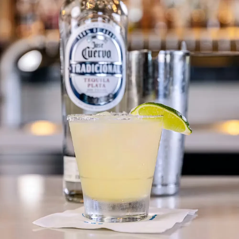 Margarita with salted rim, lime wedge, Jose Cuervo tequila, shaker.