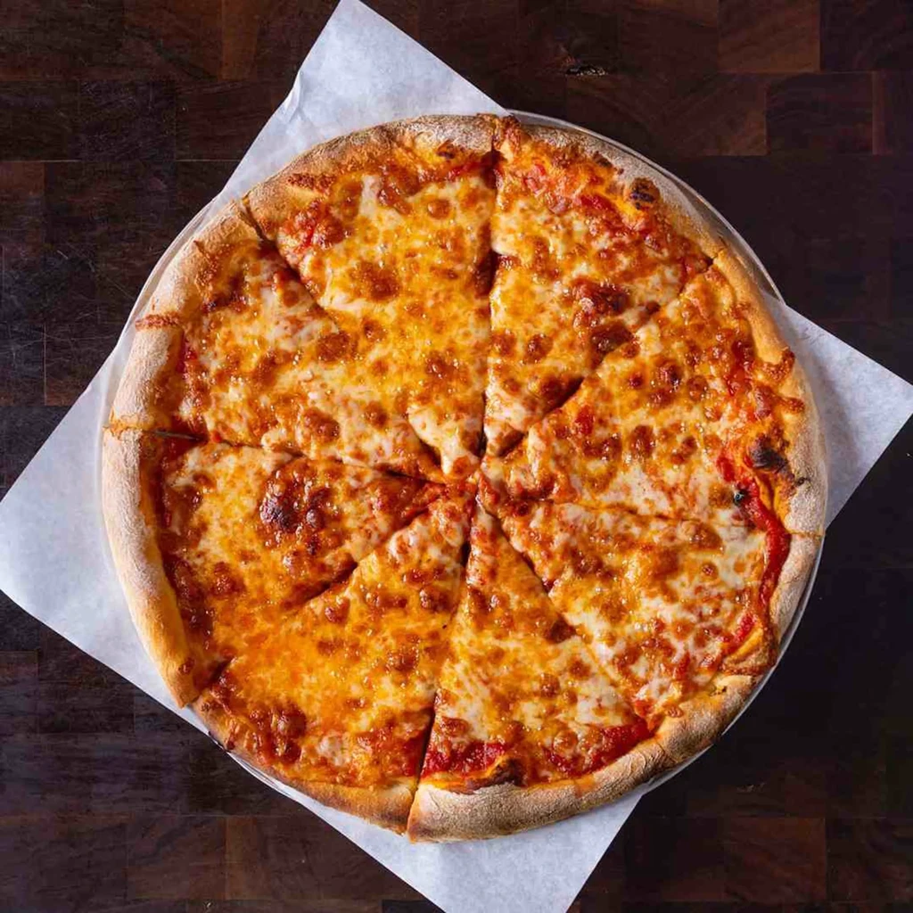 Golden-brown cheese pizza, sliced, with bubbly cheese on wood.