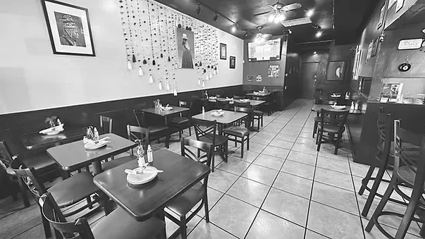 Black and white photo of an empty, casual restaurant dining area.