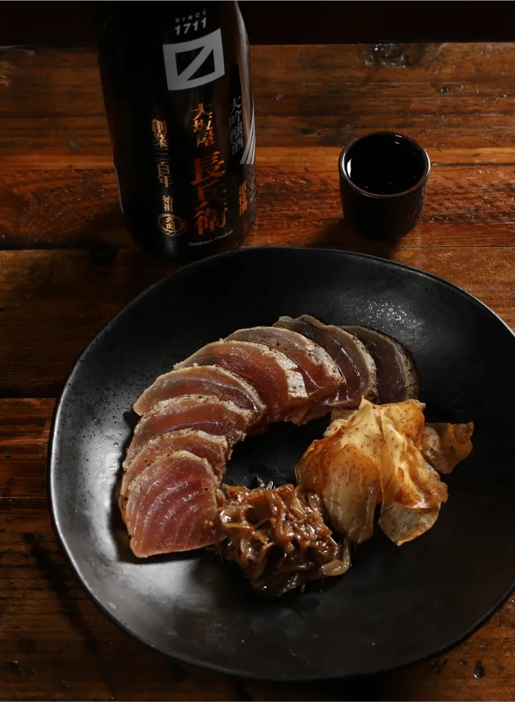 Tataki fish slices, relish, crisps, and Osakaya Chobei sake.