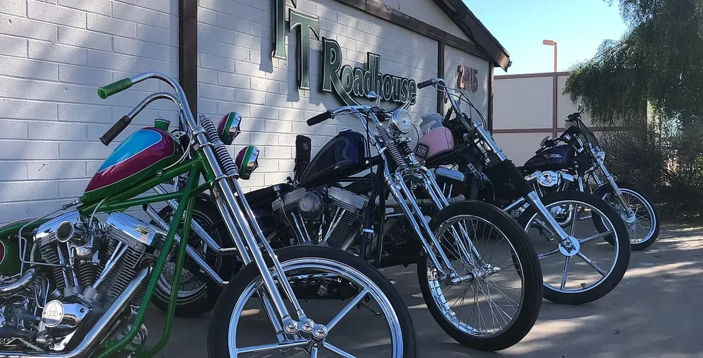 Custom choppers parked outside TJ Roadhouse; closest has green frame.