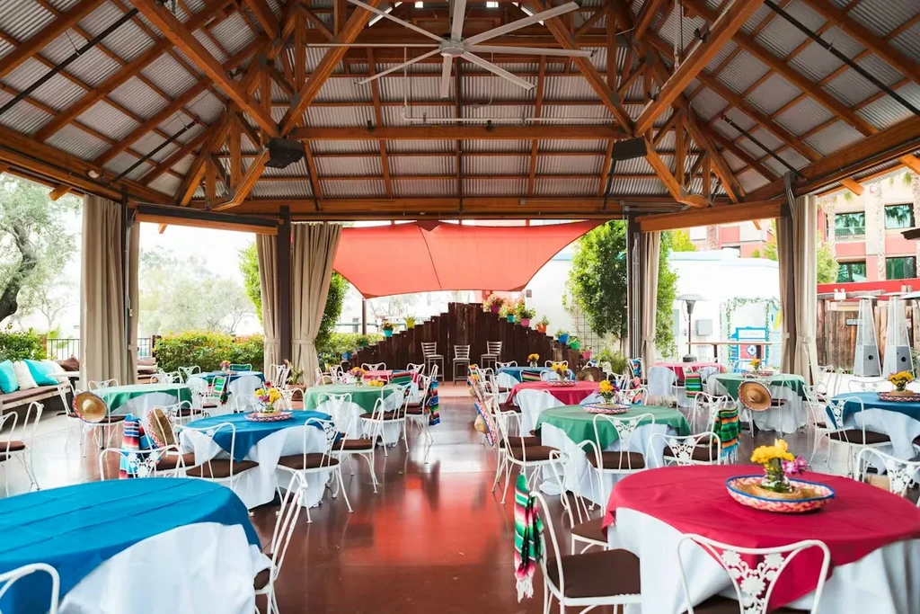 Empty vibrant Mexican-themed outdoor dining patio with colorful tables.