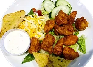 Overhead plate: buffalo chicken salad, cheese, cucumber, garlic bread, dressing.