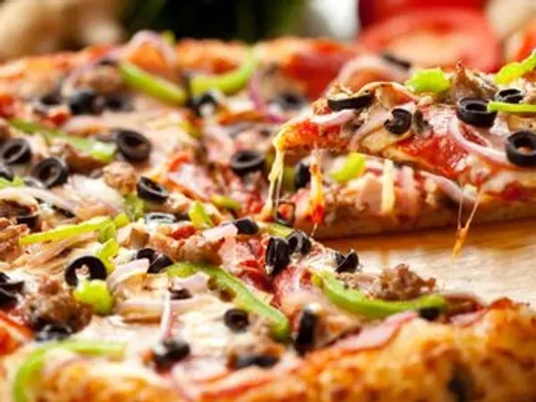 Pizza slice being lifted, showing olives, peppers, meat, and stretchy cheese.