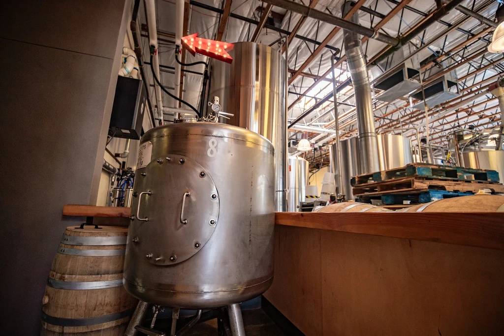 Large stainless steel fermentation tank '8' in an industrial brewery.