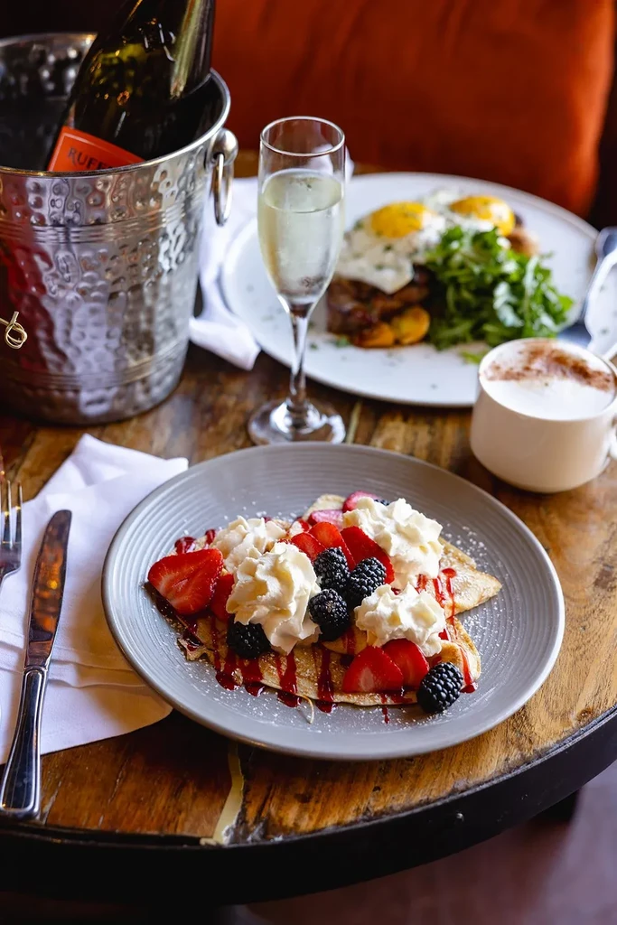 Brunch spread: berry crepes, Ruffino sparkling wine, eggs, and cappuccino.